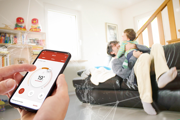 Persoon houdt smartphone in de hand met geopende Remocon Net-app. Op de achtergrond speelt een vader met zijn zoon.